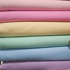 Stack of pastel-colored fabrics in various shades.
