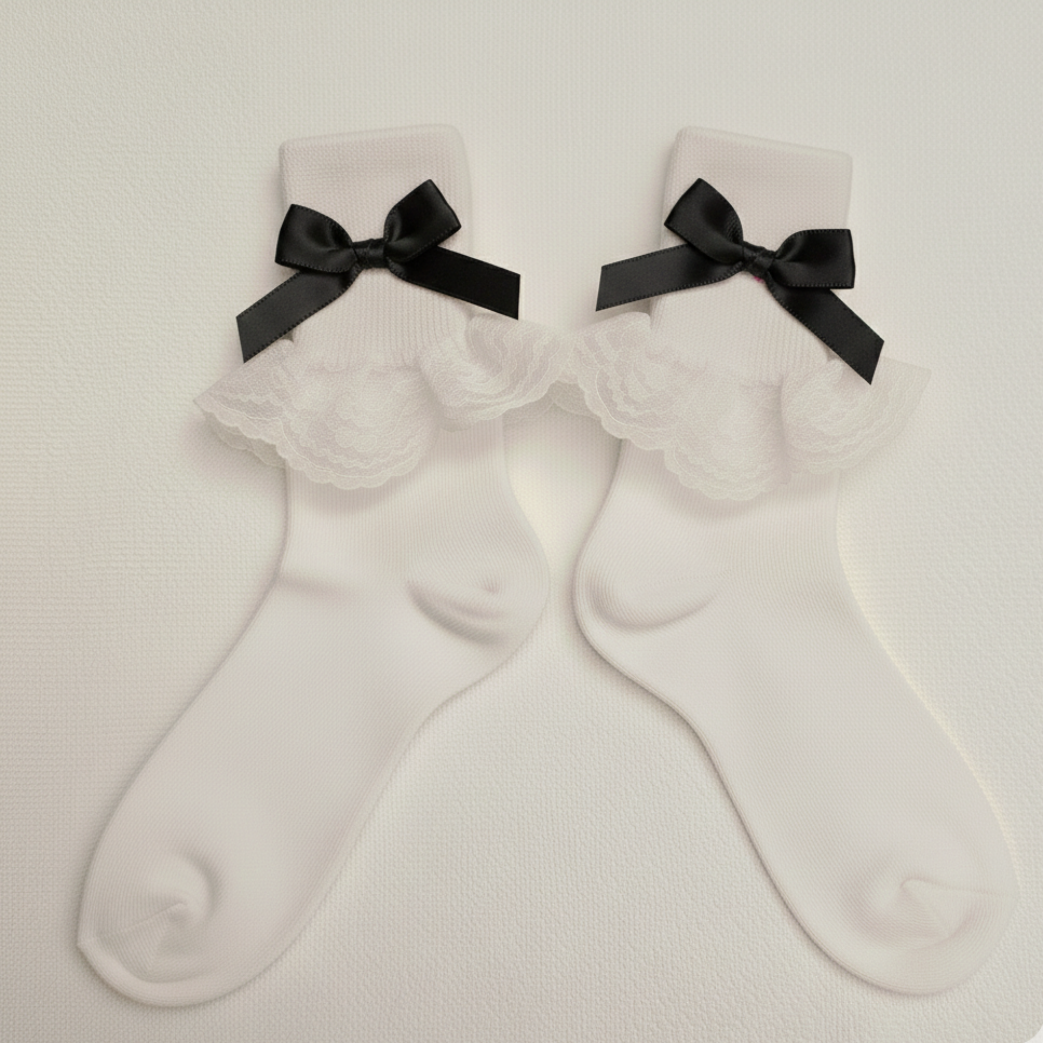 White socks with black bows on a light gray background
