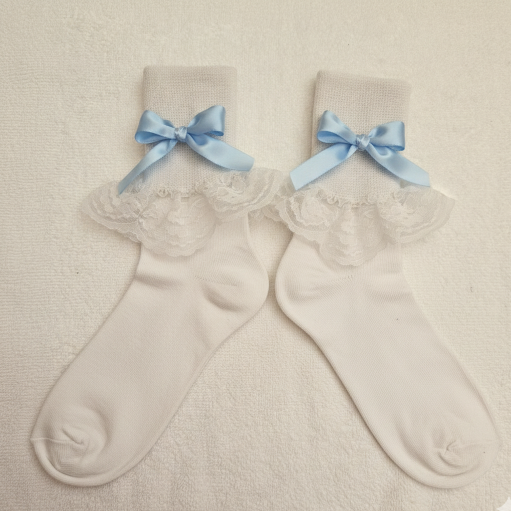 Pair of white socks with lace details and blue bows on a beige background