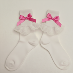 White socks with fuchsia pink bows on a light gray background
