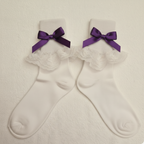 White socks with purple bows on a beige background