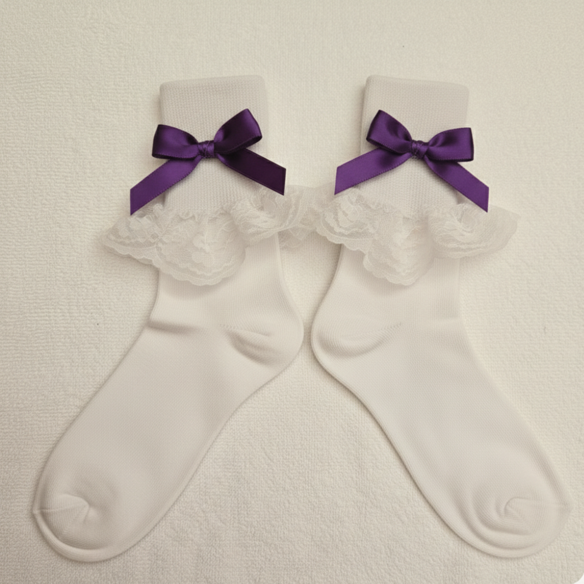 White socks with purple bows on a beige background