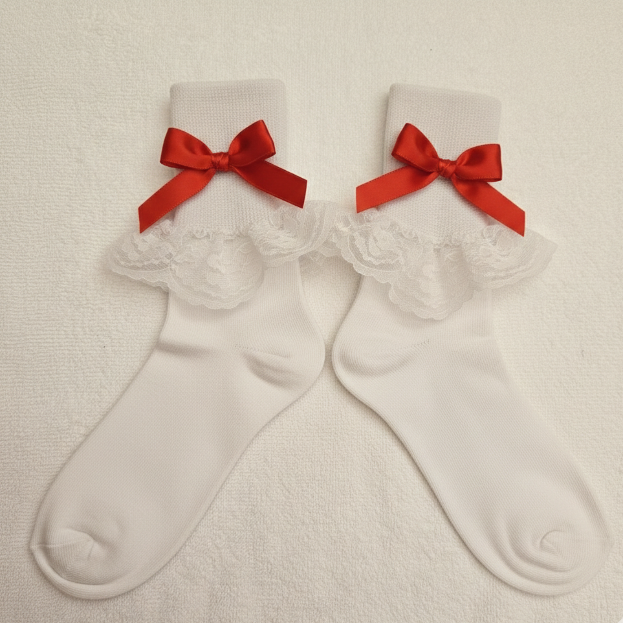 White socks with red bows on a beige background