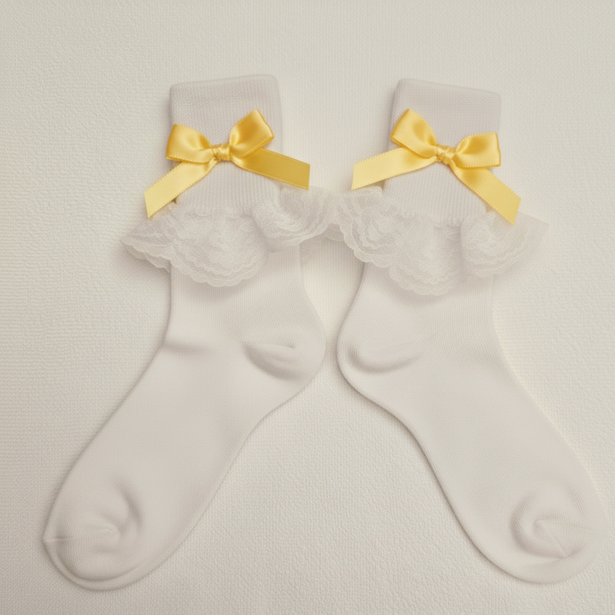 White socks with yellow bows on a light gray background