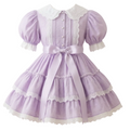 A lavender eyelet sissy dress with white lace and buttons on a white background