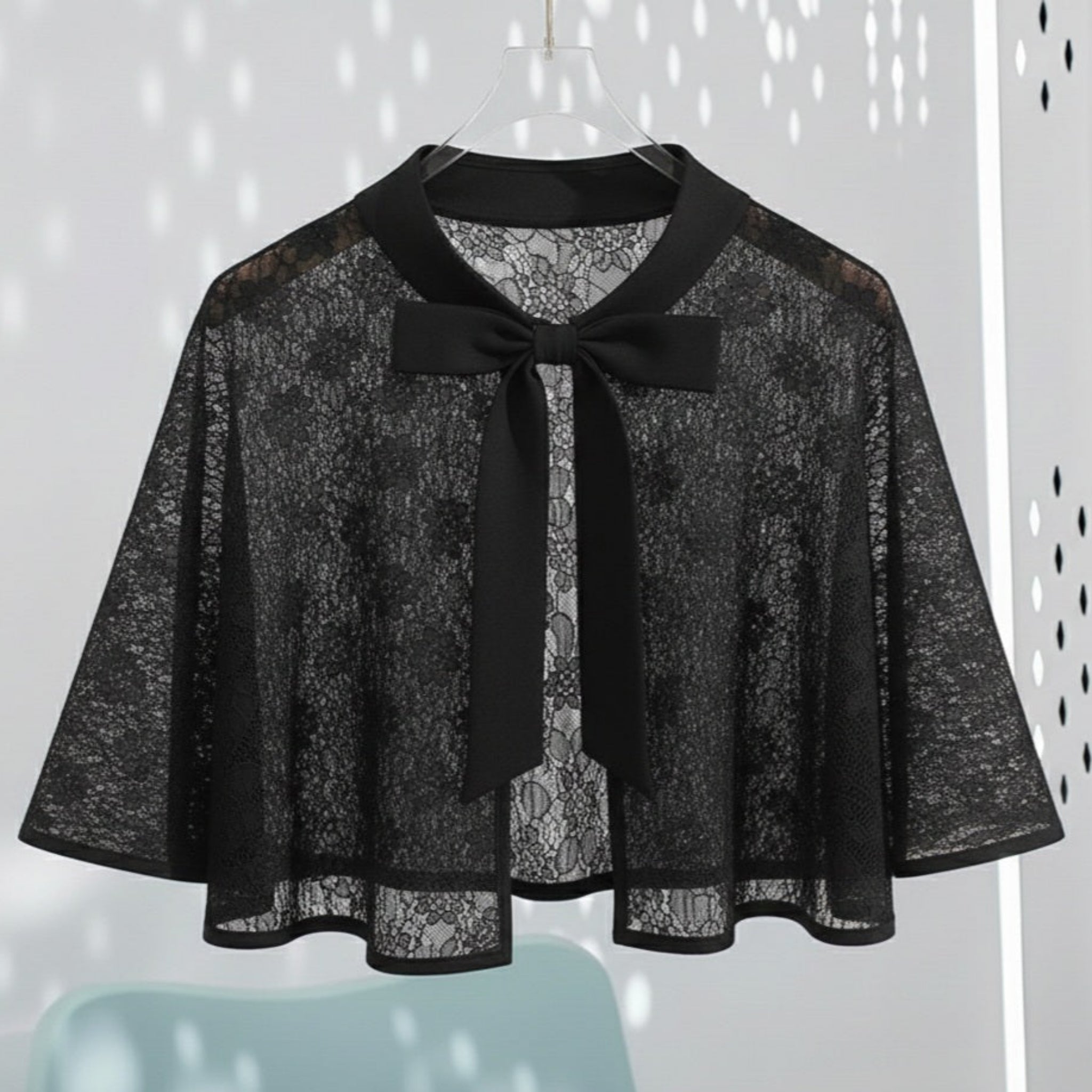 Black lace cape with a bow on a white background