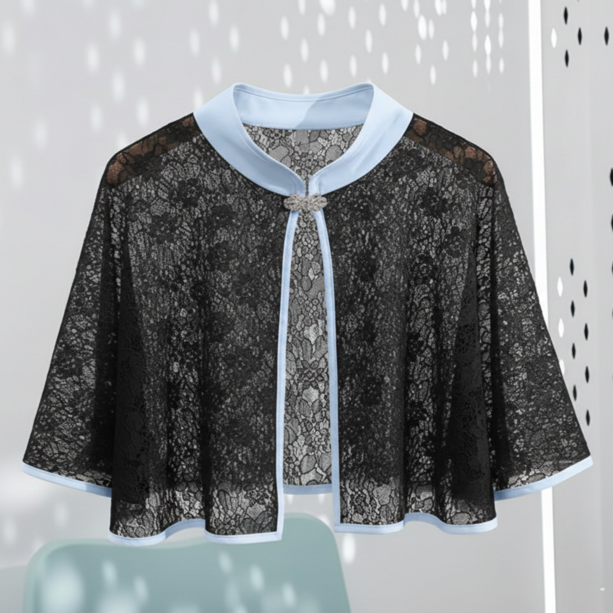 Black lace cape with Blue trim on a light gray background