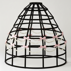 Black hoop skirt cage crinoline with pink bows and beads on a white background