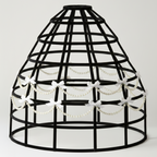 Black birdcage hoop skirt with decorative beads and bows on a white background