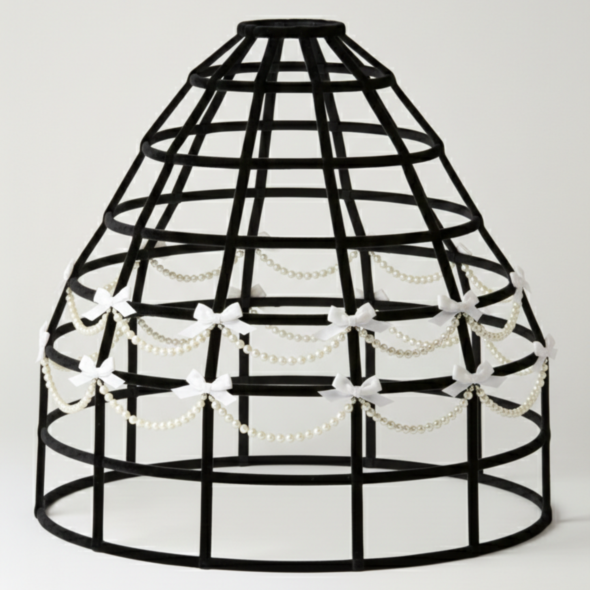 Black birdcage hoop skirt with decorative beads and bows on a white background