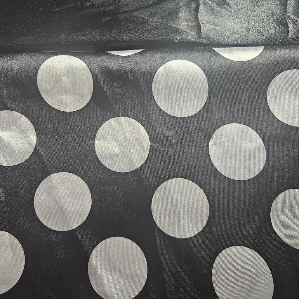 Black fabric with large white polka dots