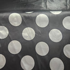 Black fabric with large white polka dots