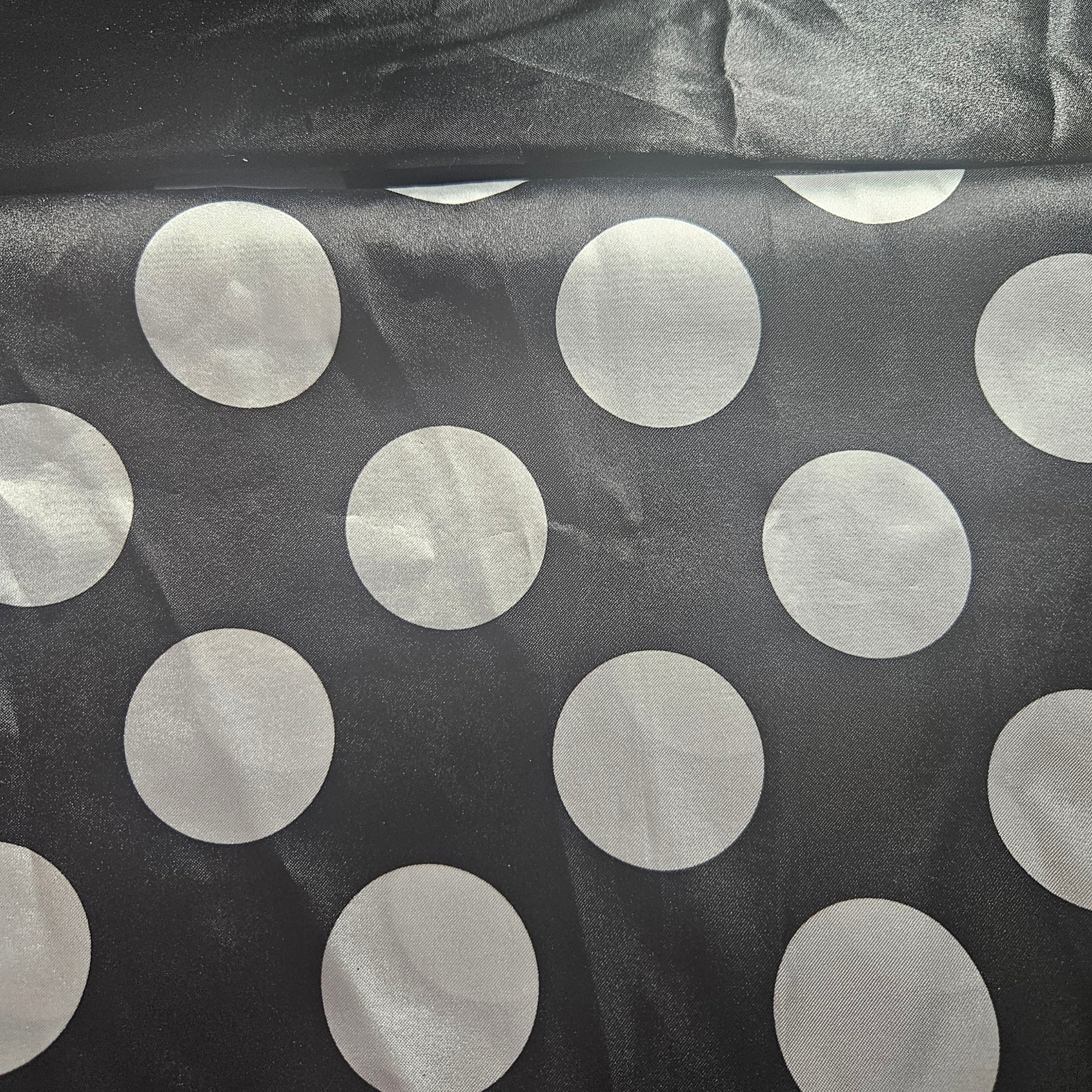 Black fabric with large white polka dots