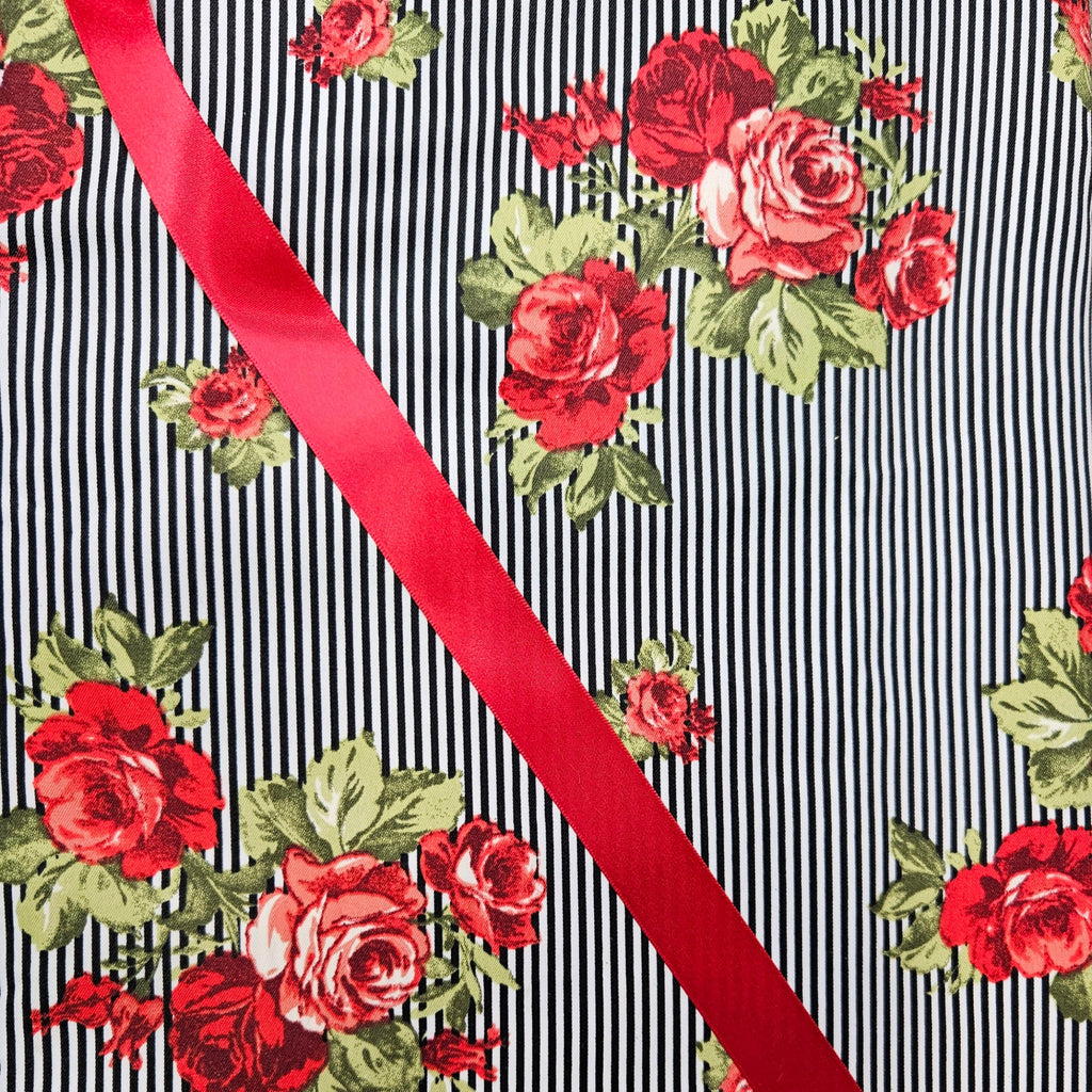 Floral pattern with red roses and green leaves on a black and white striped background with a red ribbon.