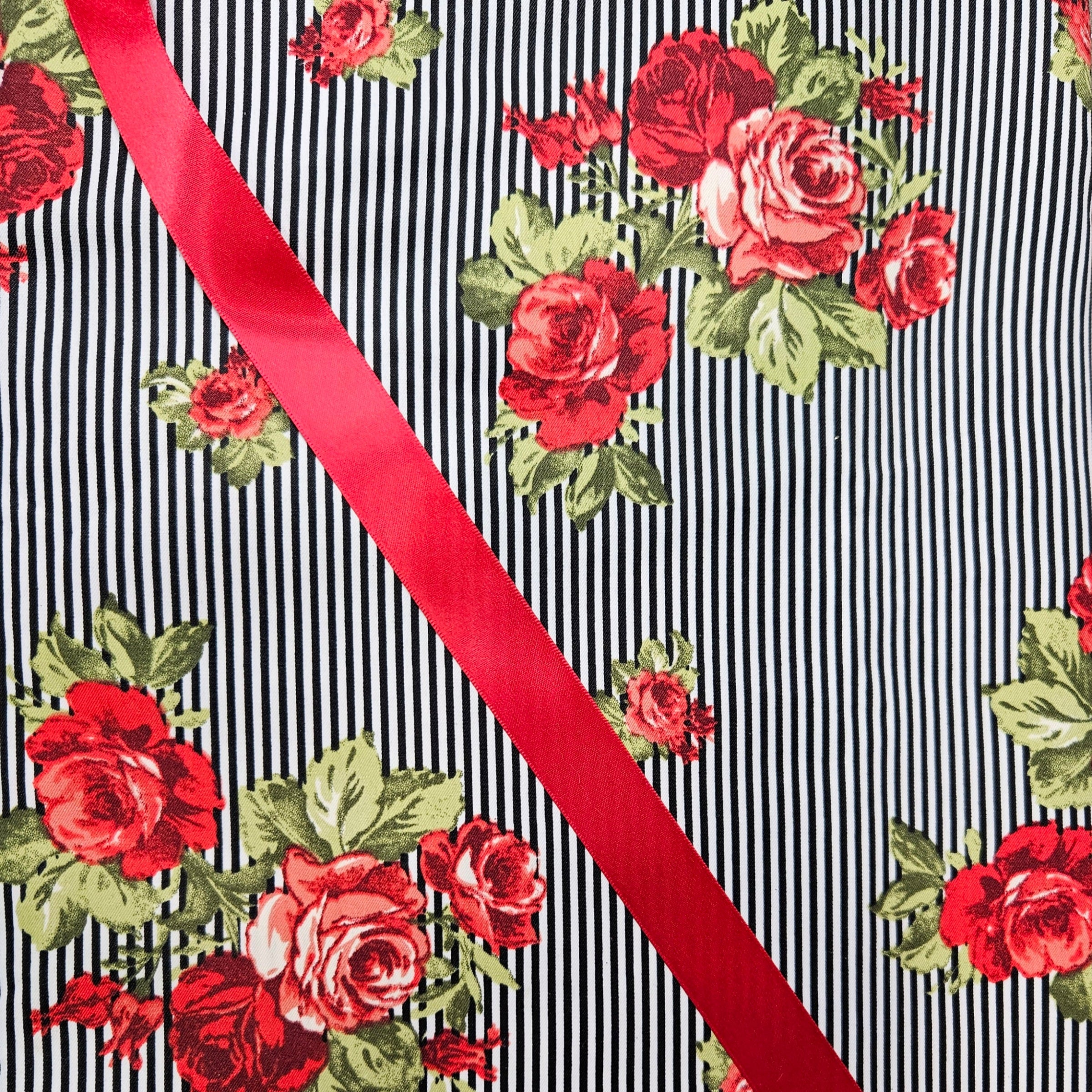 Floral pattern with red roses and green leaves on a black and white striped background with a red ribbon.