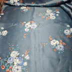 Floral patterned fabric with blue and white flowers on a dark background