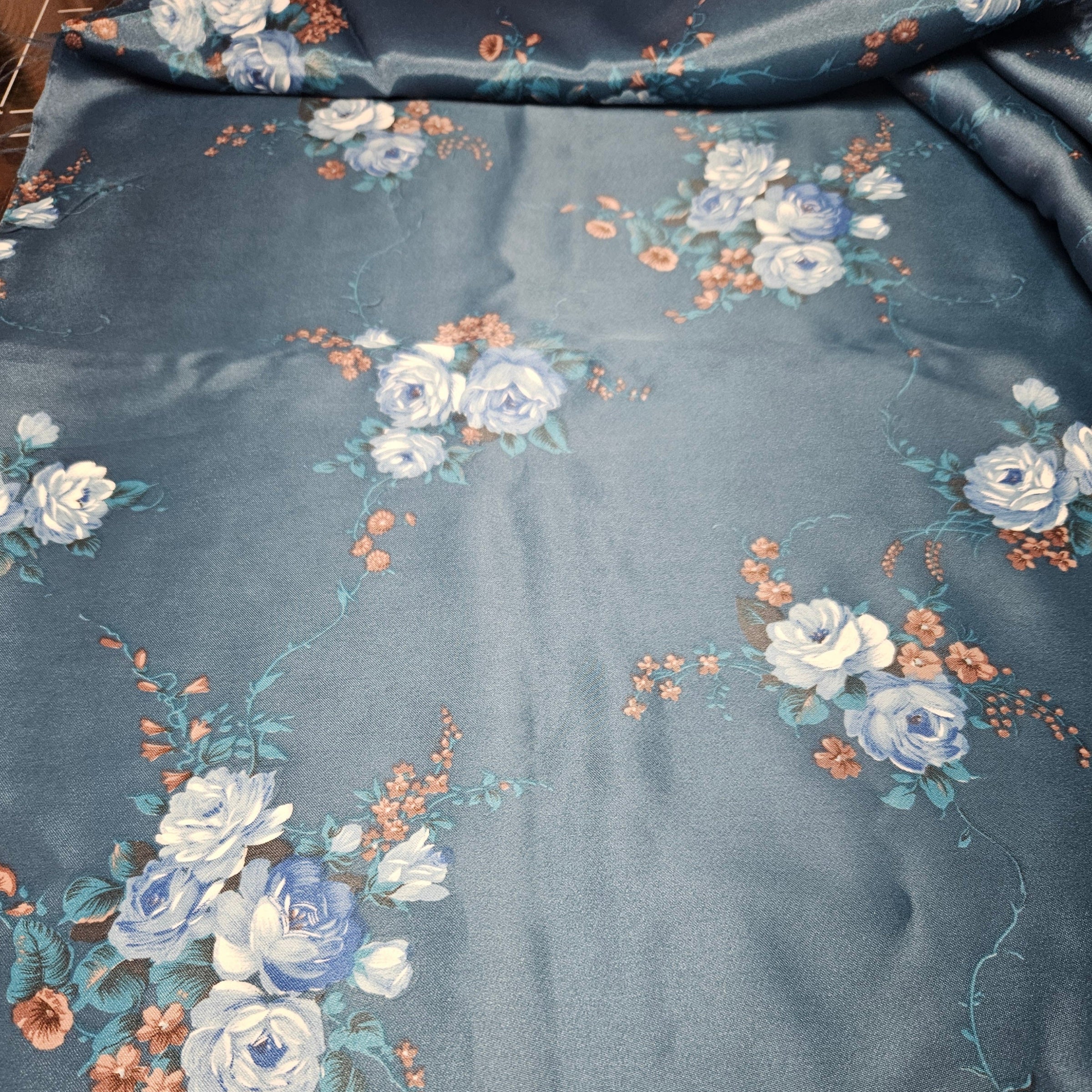 Floral patterned fabric with blue and white flowers on a dark background