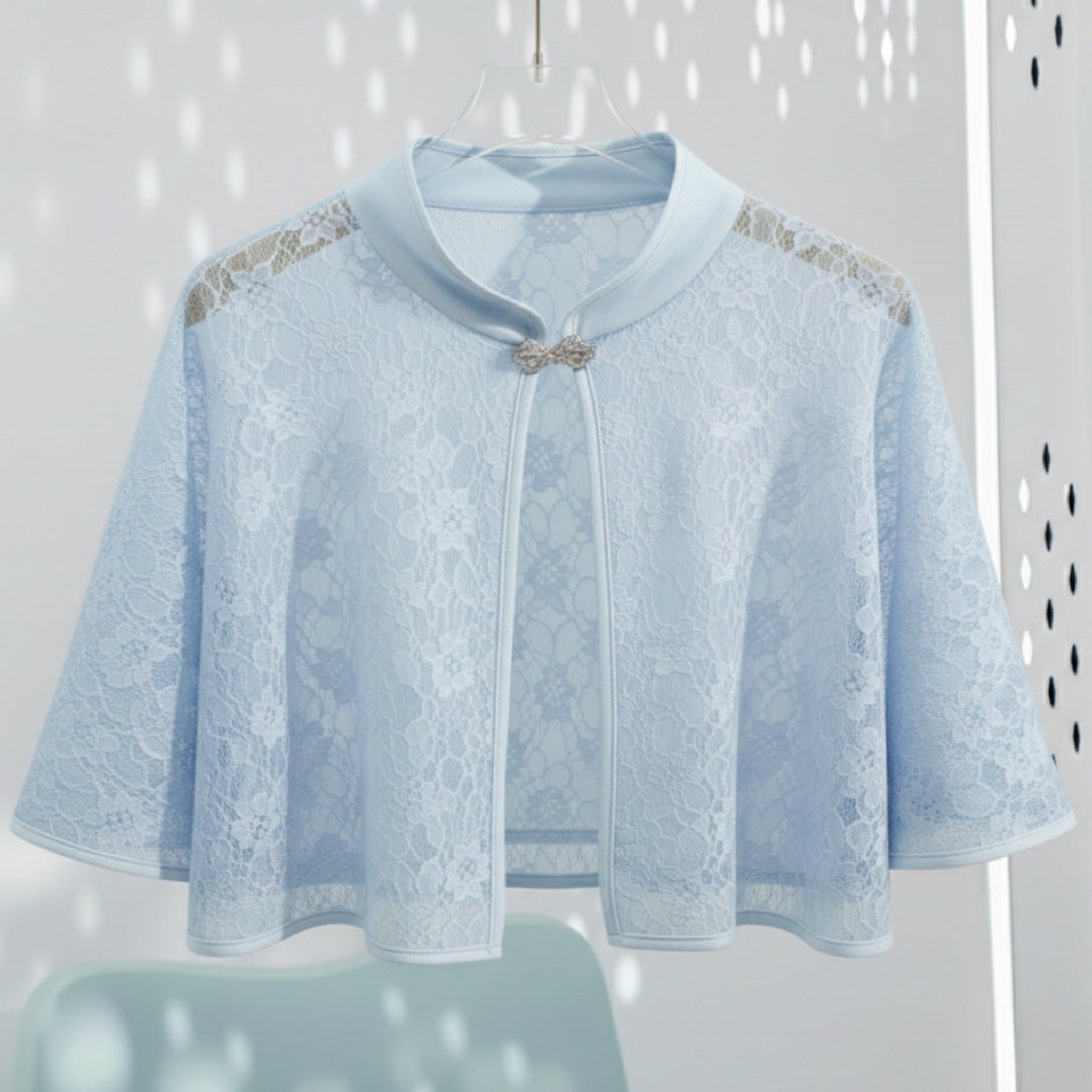Light blue lace cape with decorative trim on a white background