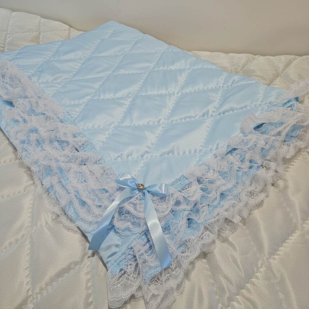 Blue lace baby snuggle blanket on a white quilted surface