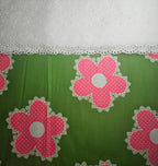 Green fabric with pink floral patterns and white lace trim