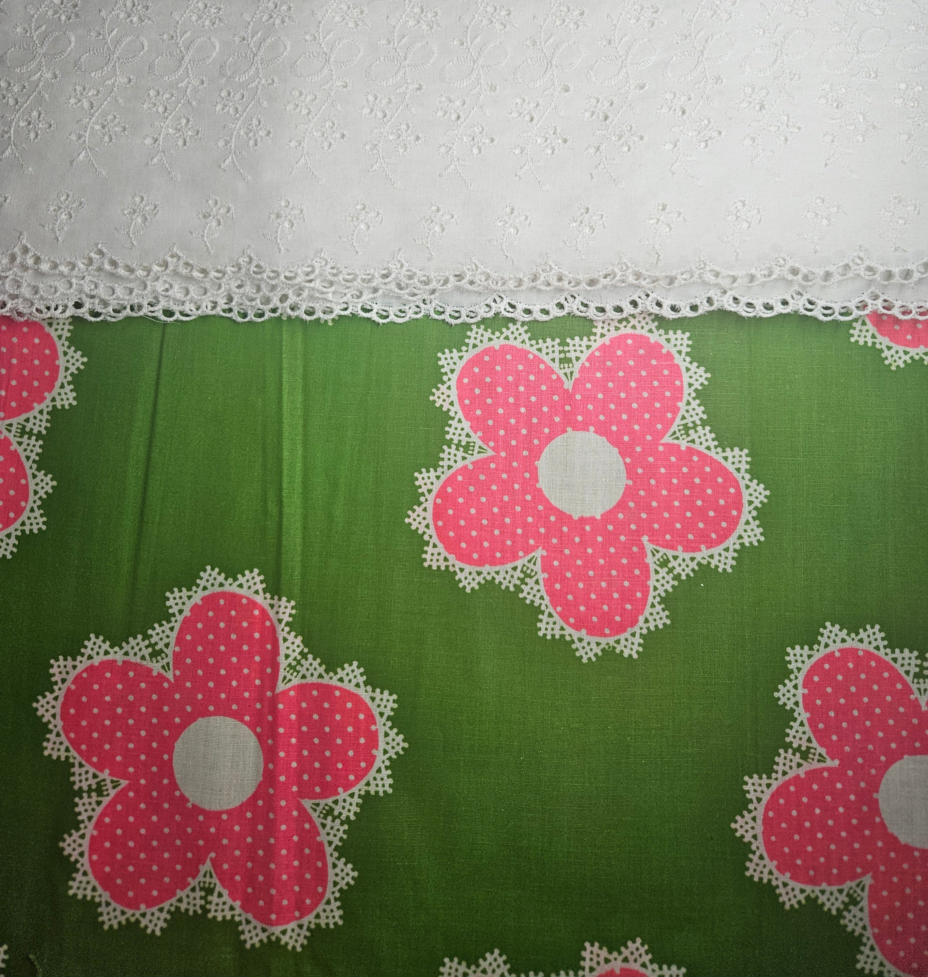 Green fabric with pink floral patterns and white lace trim