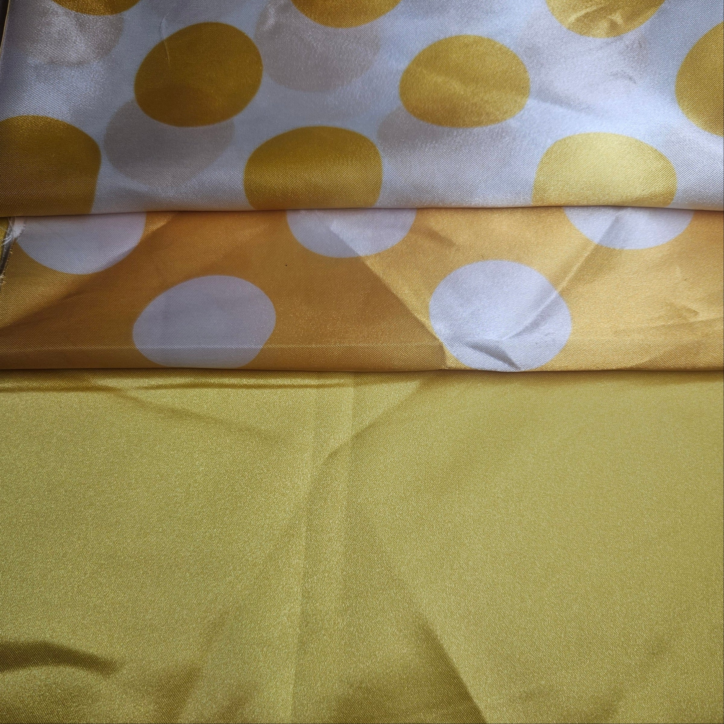 Golden Yellow fabric with white polka dots on a plain background