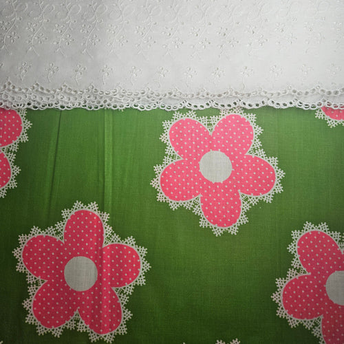 Green fabric with pink floral patterns and white lace trim