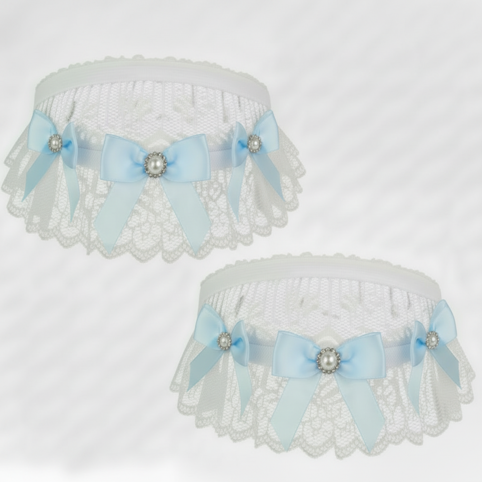 White lace garters with blue ribbons and pearl accents on a light gray background