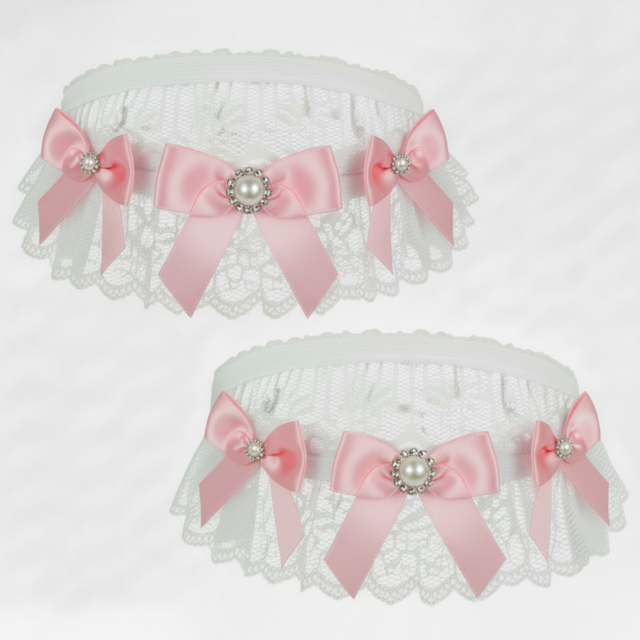 White lace garters with pink bows and pearl centers on a white background