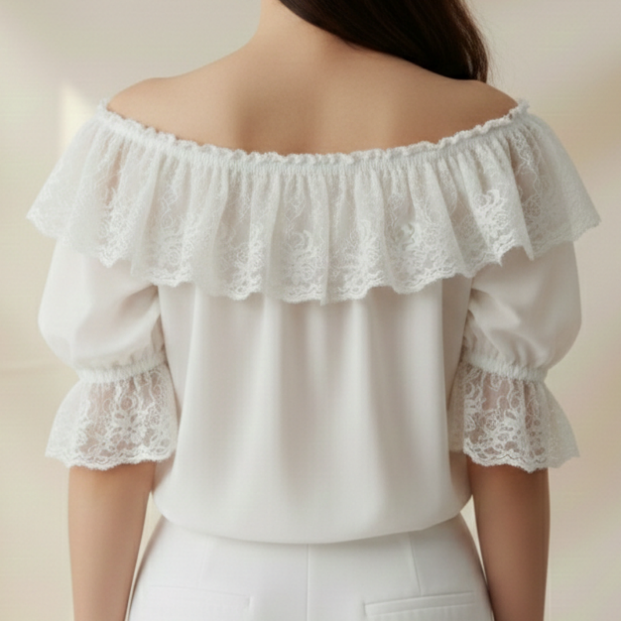 White off-shoulder top with lace details on a neutral background