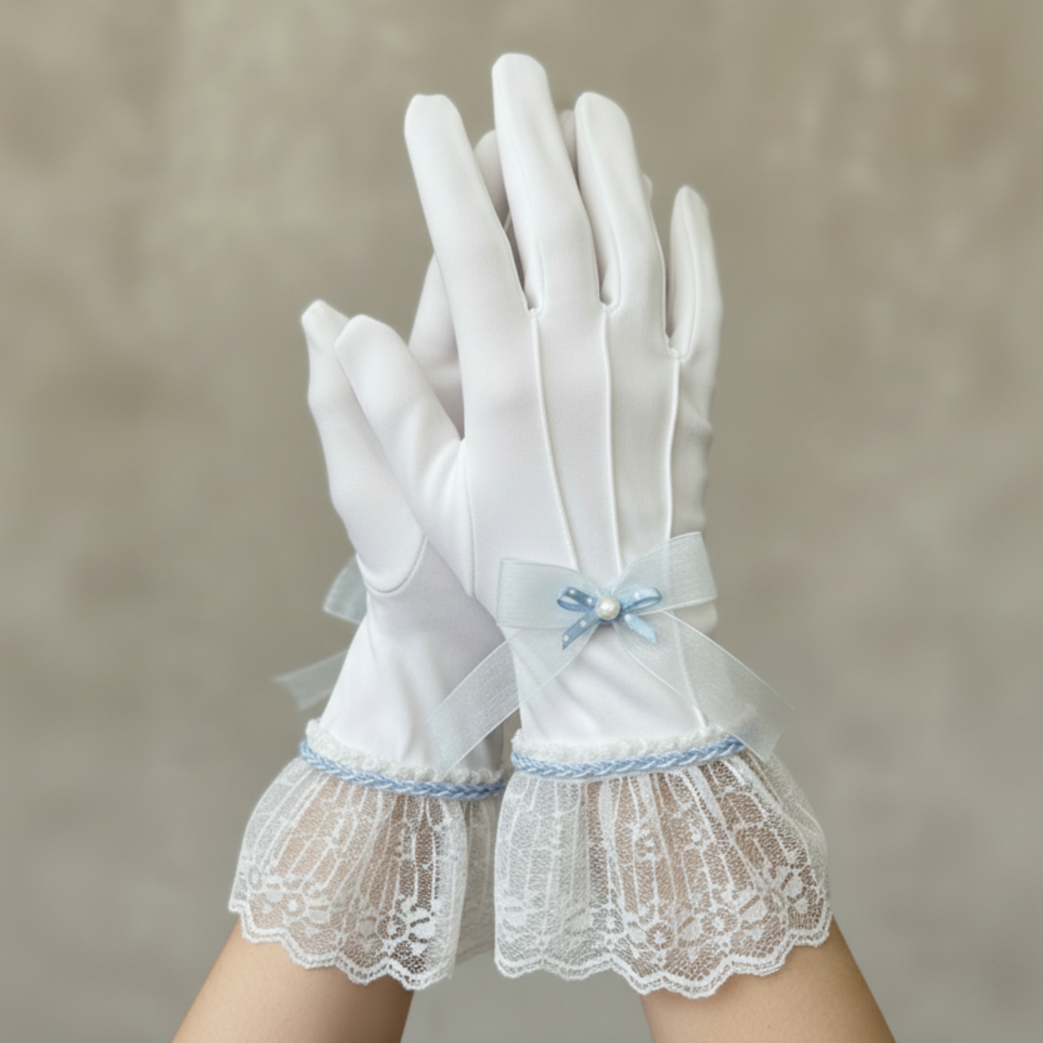 White gloves with lace and a bow on a neutral background