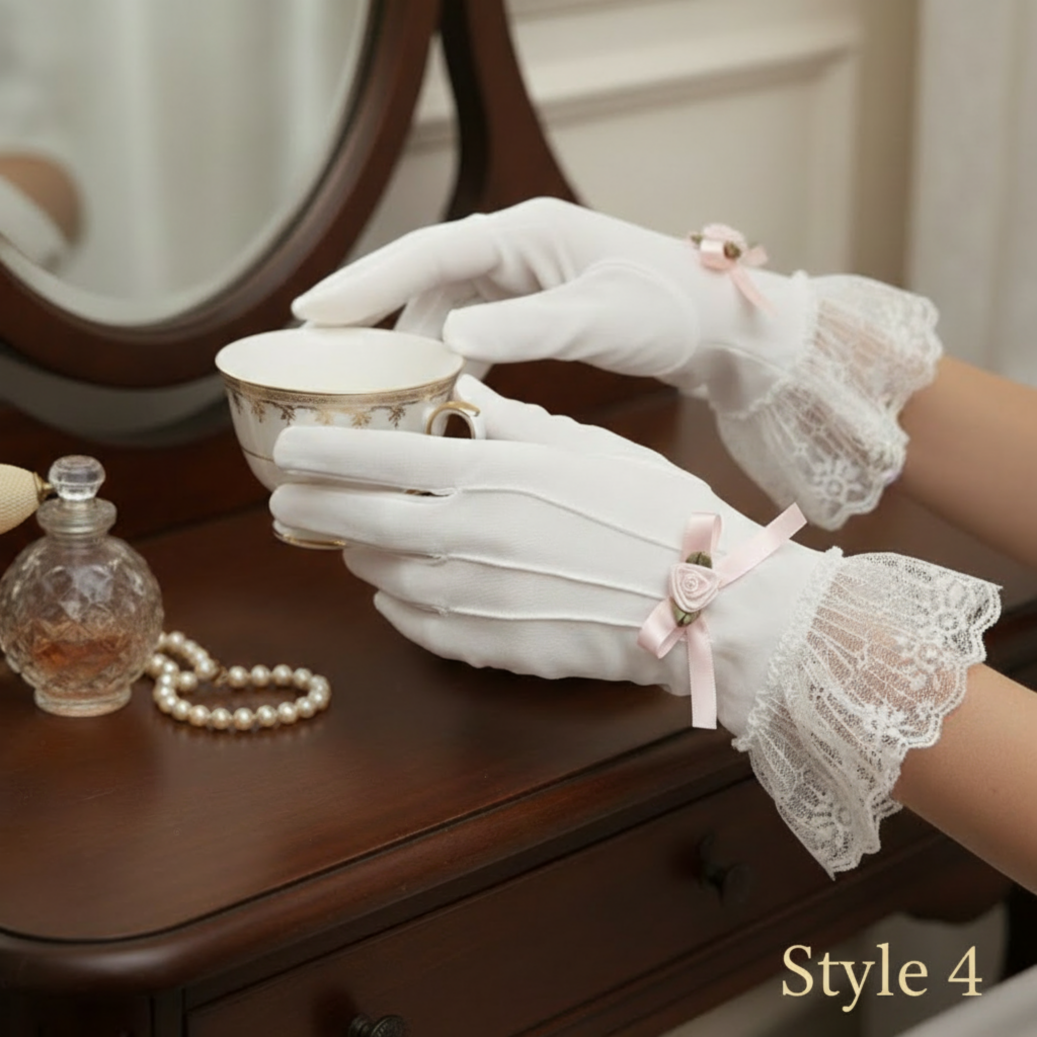 Person wearing white lace gloves holding a teacup on a wooden dresser.