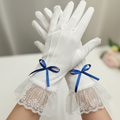 White gloves with lace cuffs and blue ribbons on a neutral background