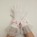 White lace gloves with pink bows on a neutral background
