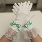 White gloves with lace cuffs and mint green bows on a neutral background