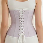 Person wearing a light purple waist trainer corset over a white tank top and pants.