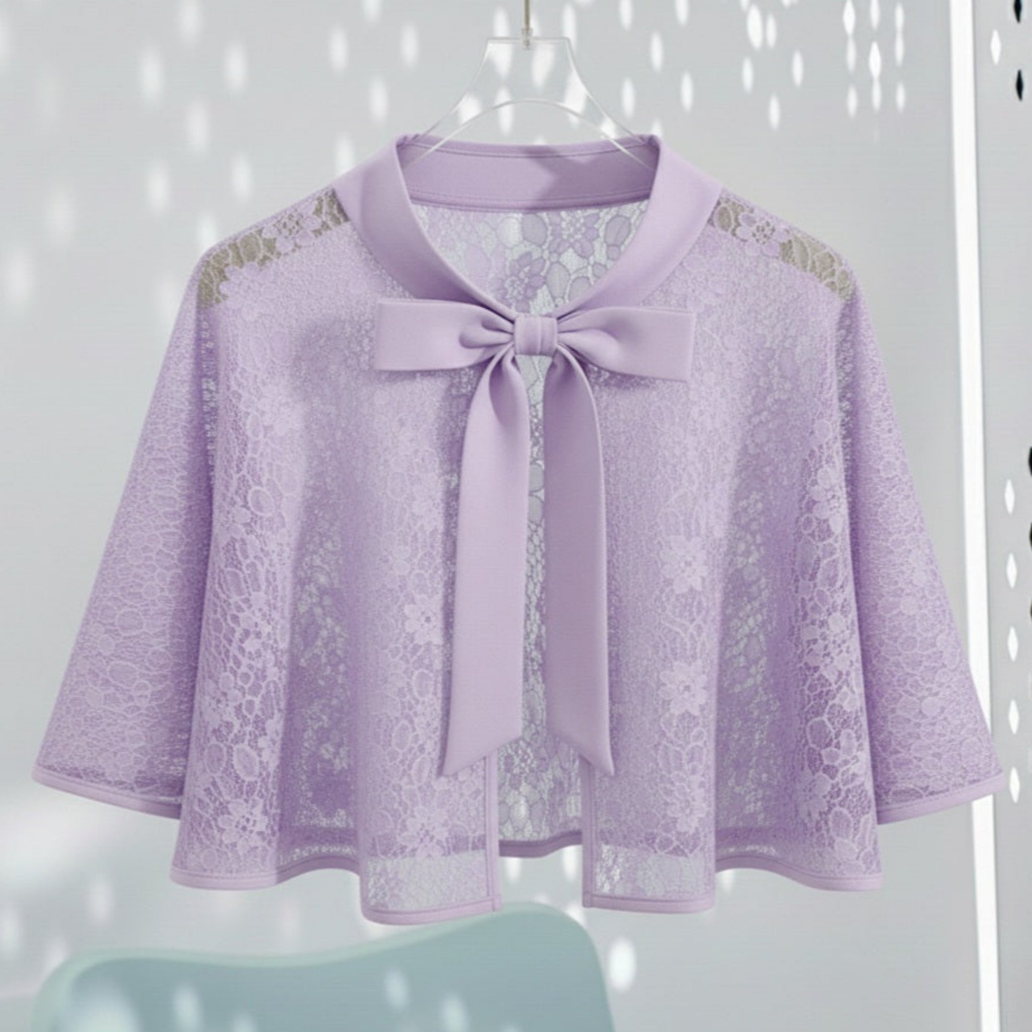 Lavender lace cape with a satin bow tie on a white background