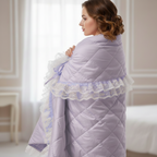 Woman wrapped in a lavender snuggle quilt with lace trim in a bedroom setting