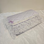 Lavender snuggle quilt with lace trim on a light gray background