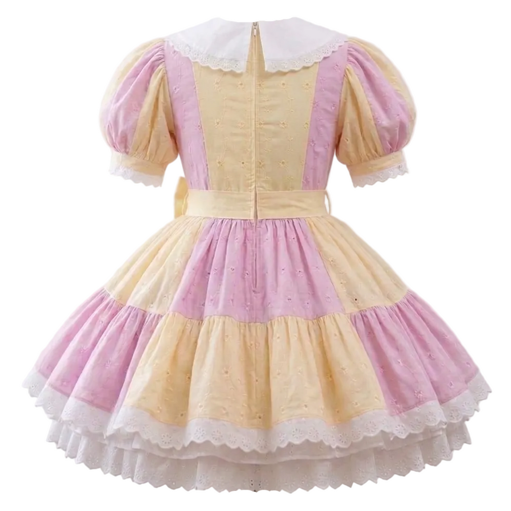 A pink and yellow eyelet sissy dress on a plain white background