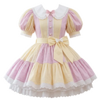 A pink and yellow eyelet sissy dress with white lace, buttons, and bows
