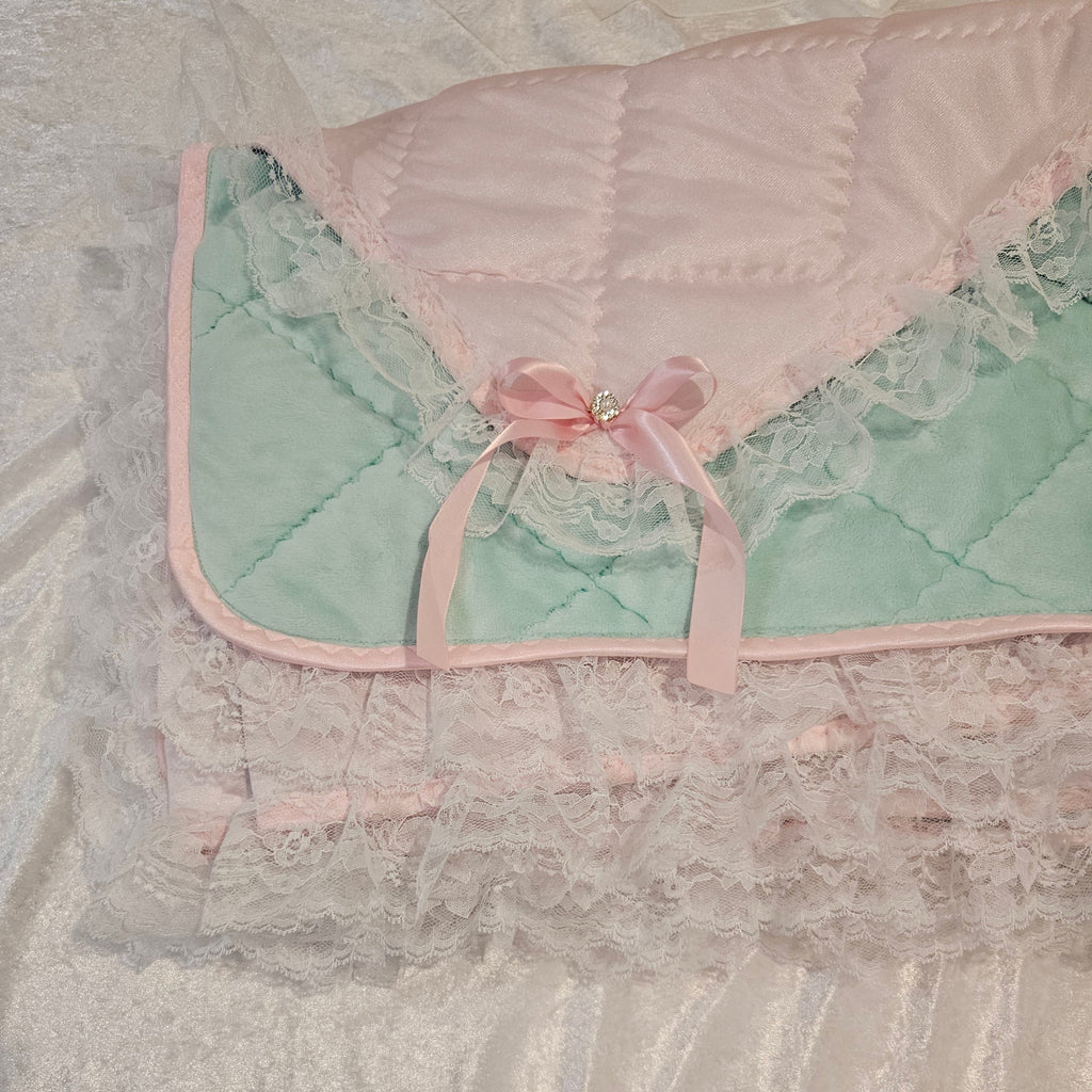 Adult Baby snuggle quilt with pink and green design on a textured surface