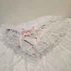 Close-up of a lace snuggle blanket with a pink ribbon on a plain background