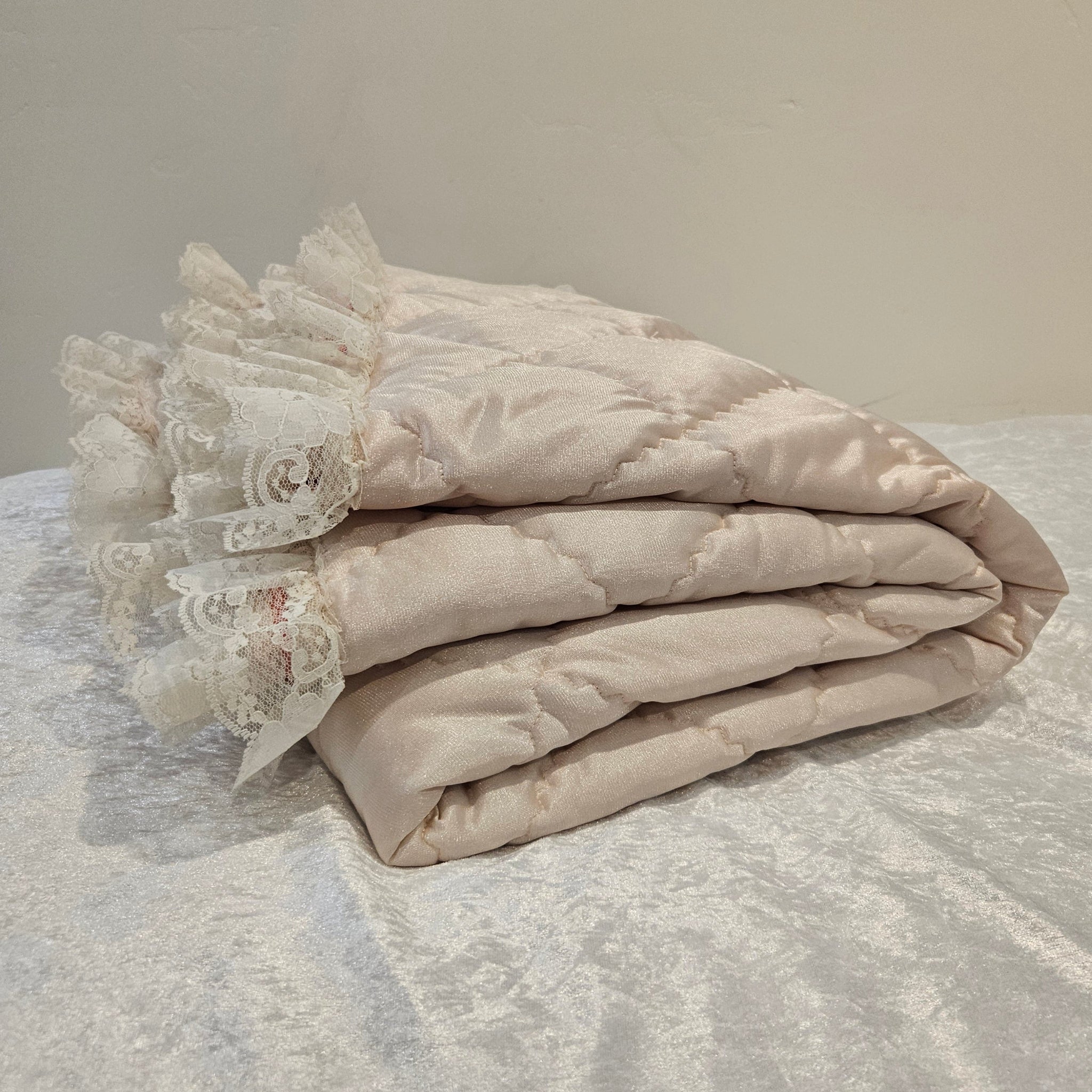 Peach lace-trimmed snuggle blanket against a white velour background