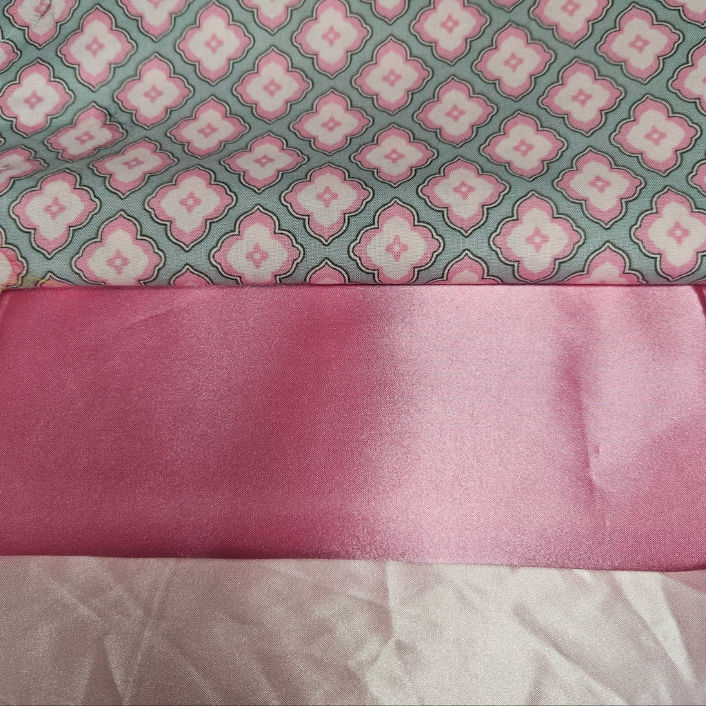 Pink fabric with a floral pattern on a gray background