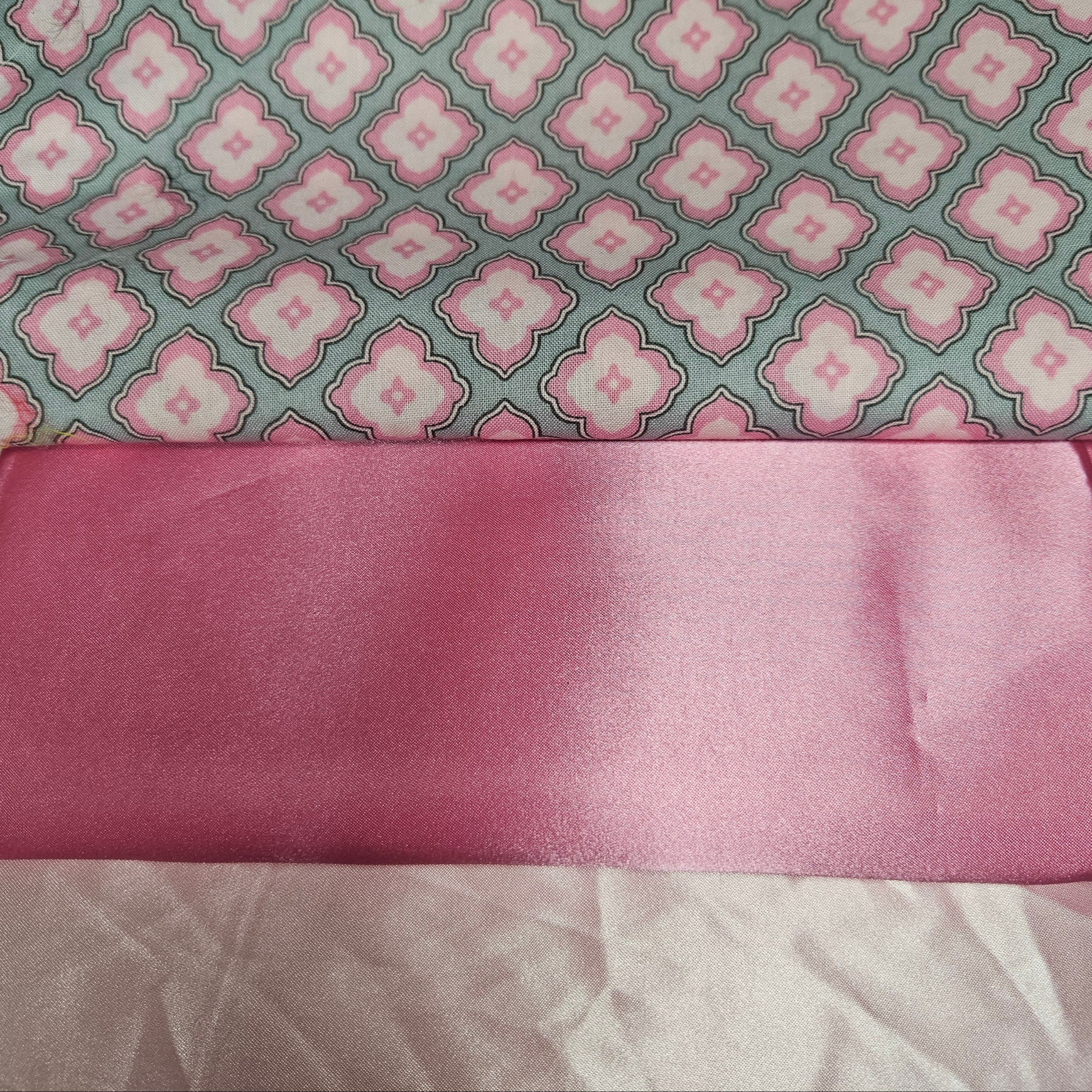 Pink fabric with a floral pattern on a gray background