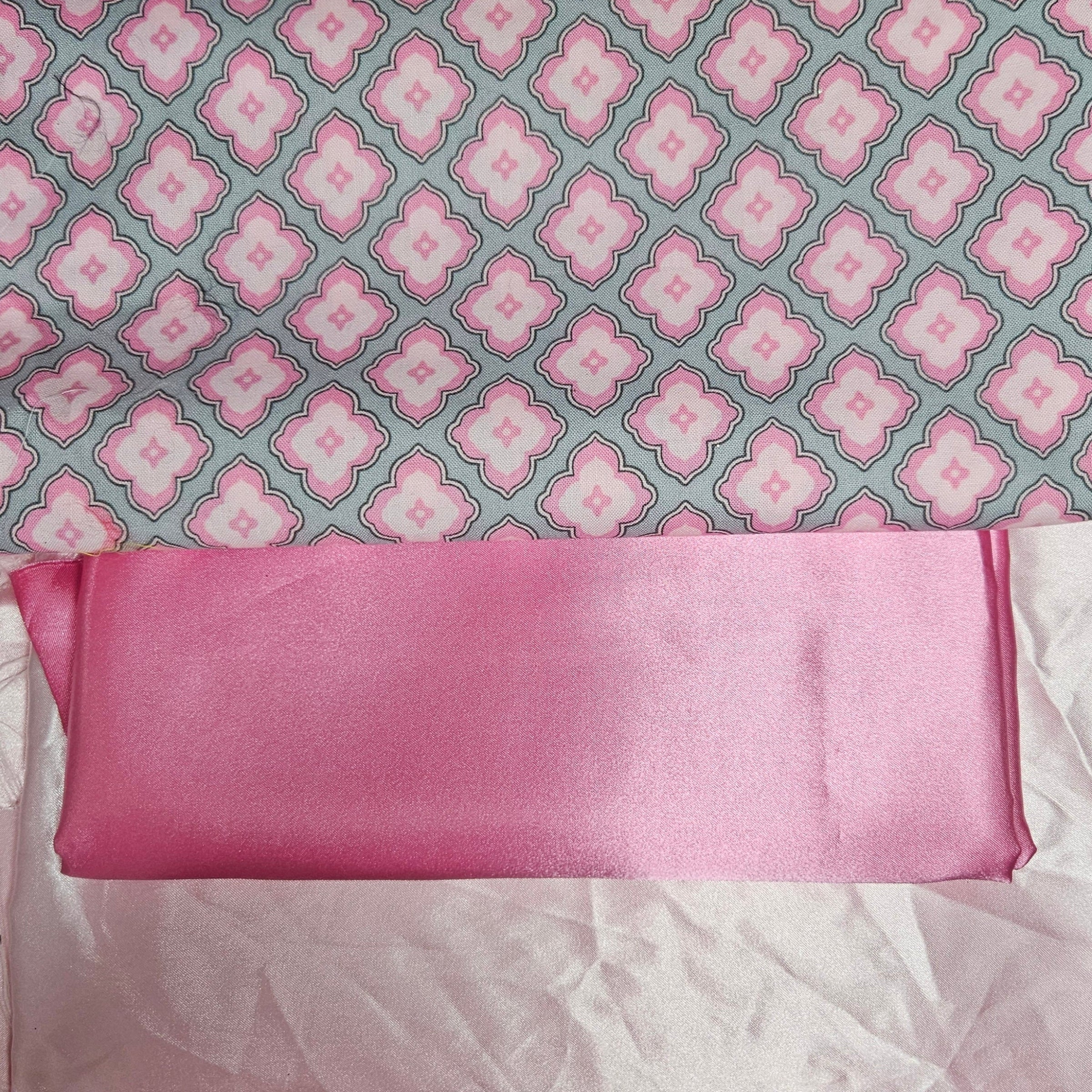 Pink satin fabric with a patterned gray and pink background
