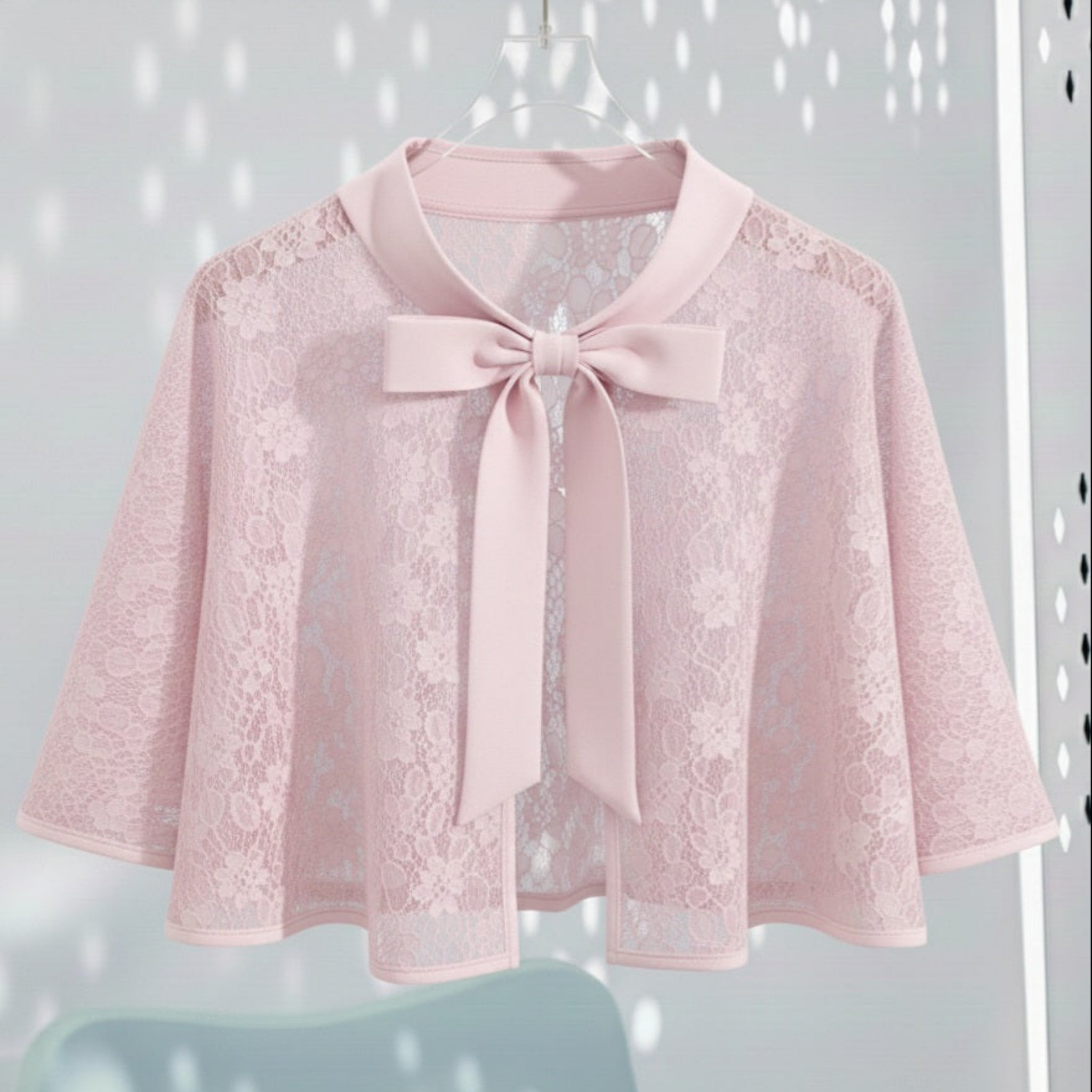 Pink lace cape with a Satin bow Tie on a light gray background