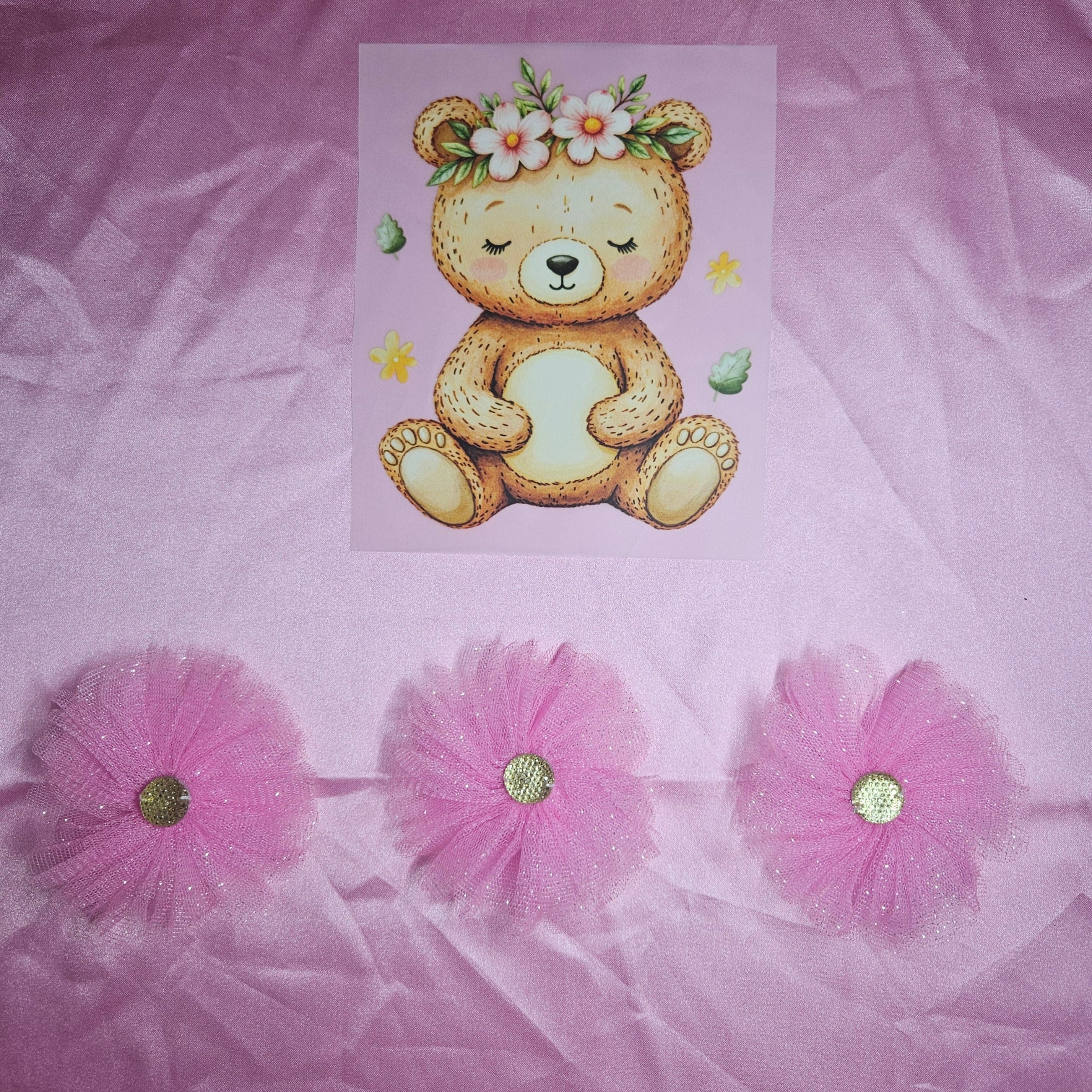 Illustration of a teddy bear applique with flowers on a pink satin background