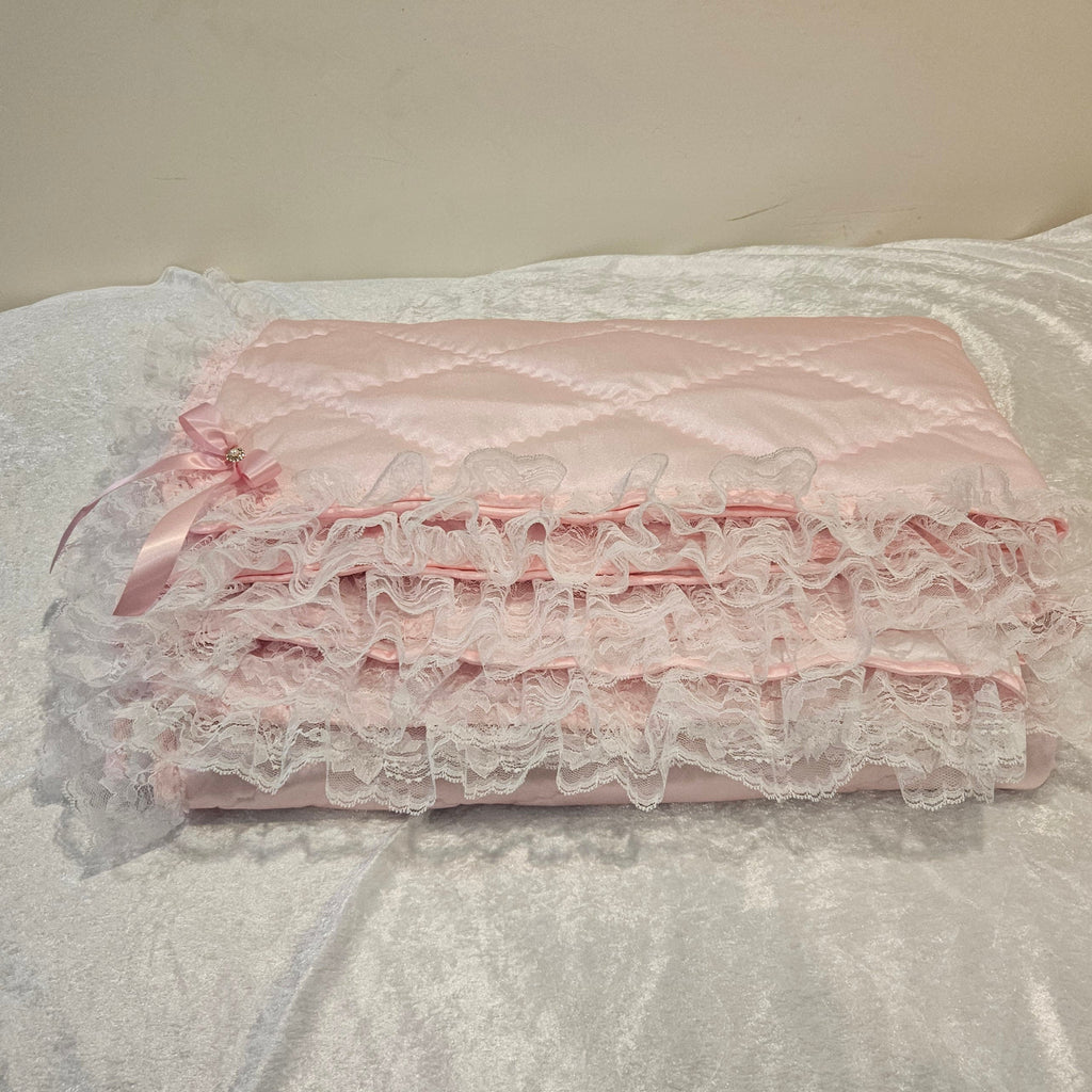 Pink lace snuggle blanket on a textured white surface